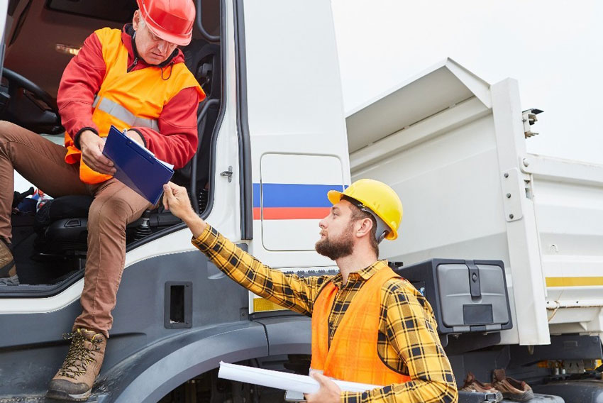 Voznik tovornjaka v pogovoru z vodjo - simbolna fotografija za zavarovanja o odgovornosti