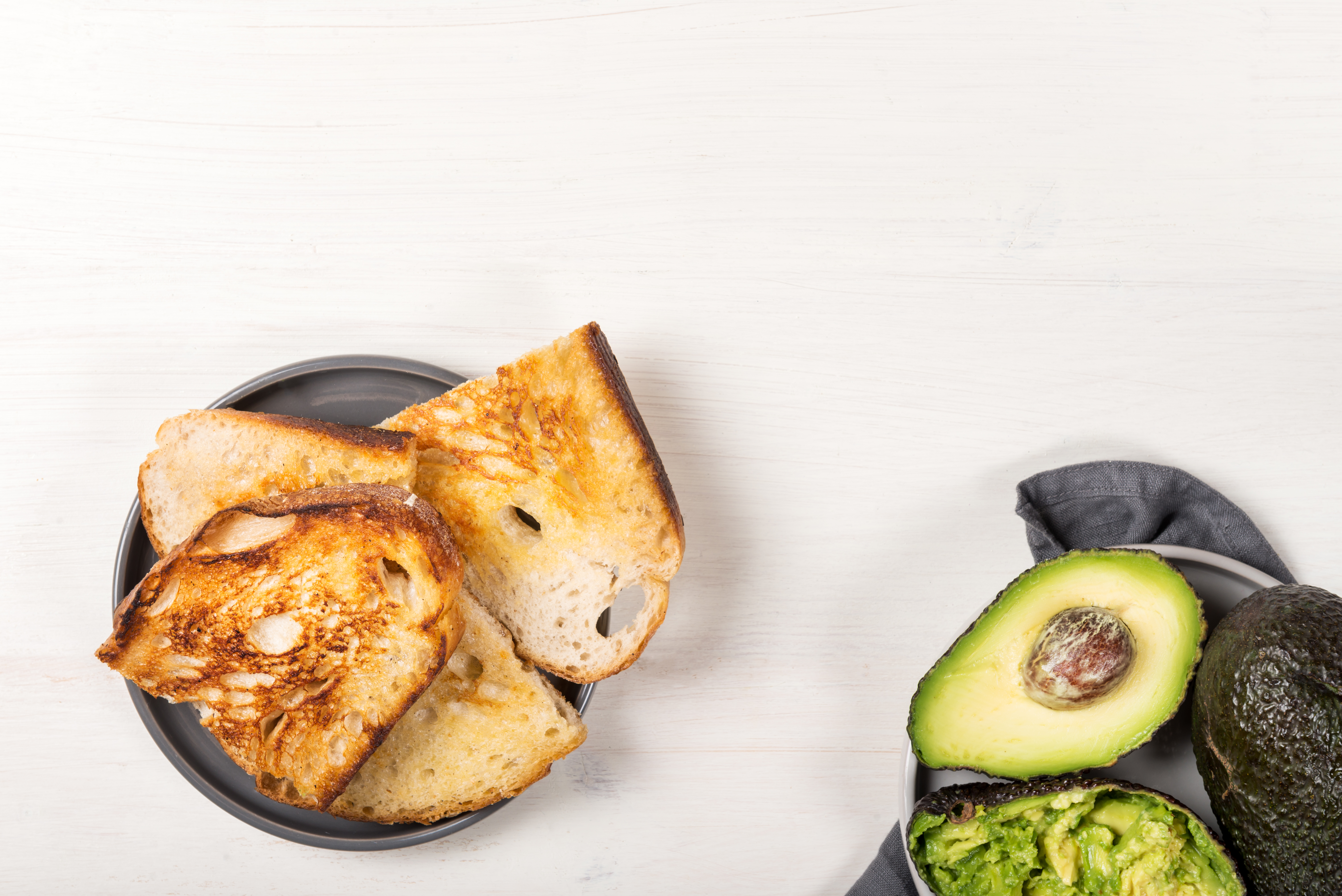 Pieces of toasted white sourdough bread and ripe avocado