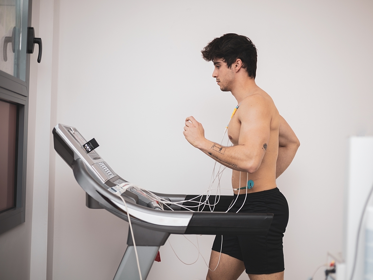 A male patient runs on a treadmill while undergoing an ECG stress test.