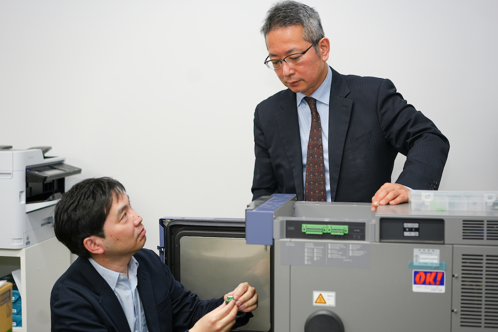 温度サイクル試験の実験装置にサンプルを設置している森氏（東京大学 桜井研究室）と阿川氏