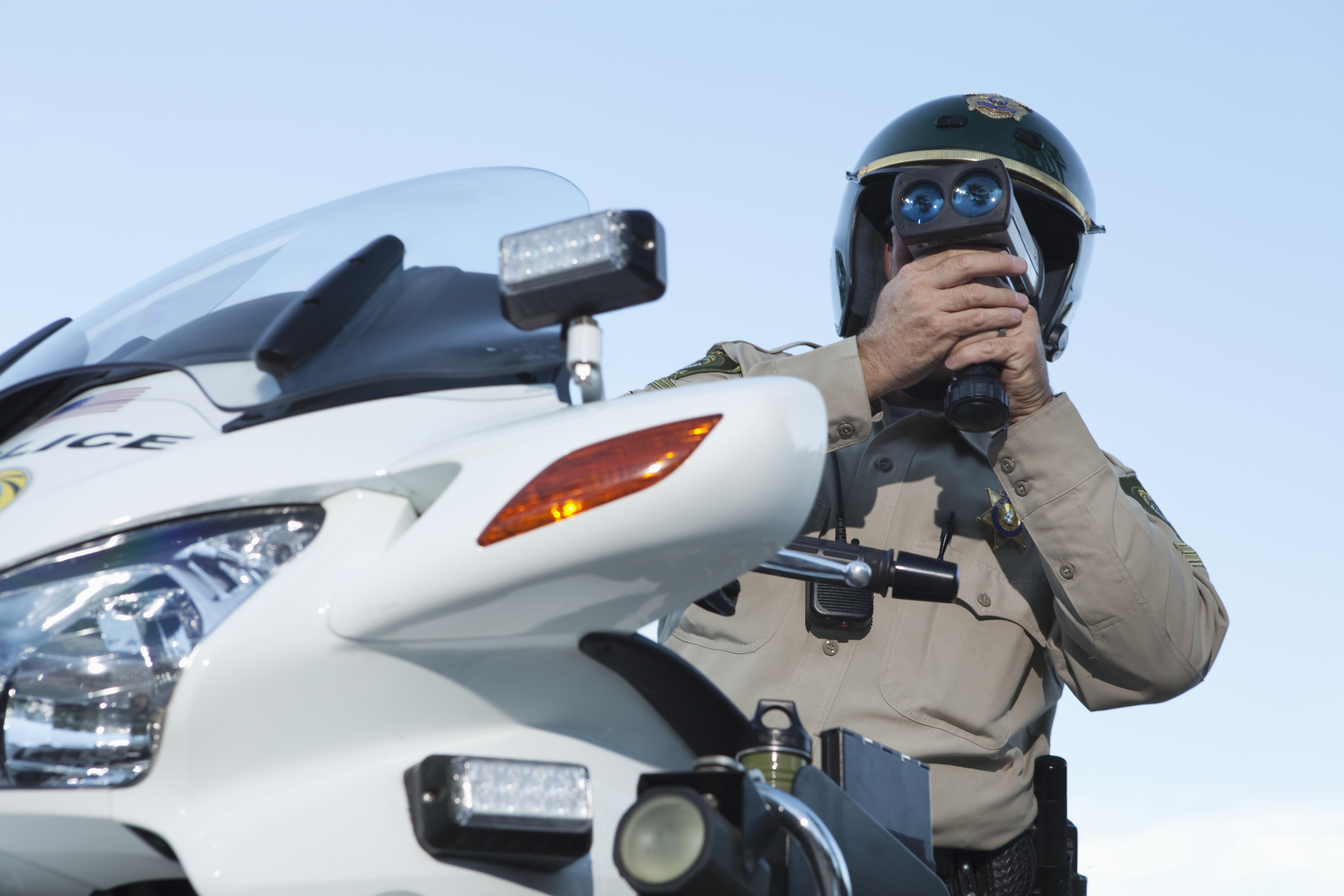 A police offer utilizing law enforcement technology to check traffic speed.