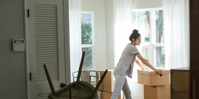 woman_with_moving_boxes_in_house.webp