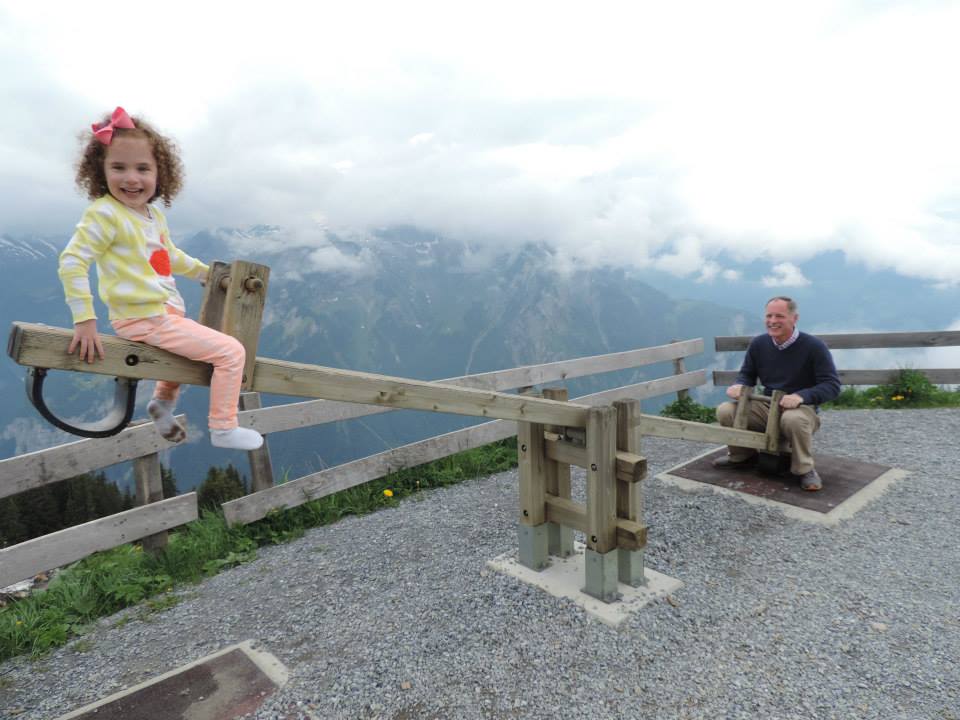 Moore teeter-totters with his daughter in the Alps.