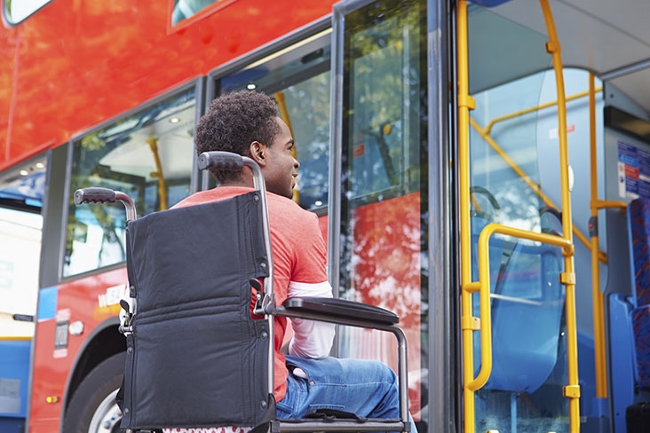 Man in wheelchair boarding a public bus