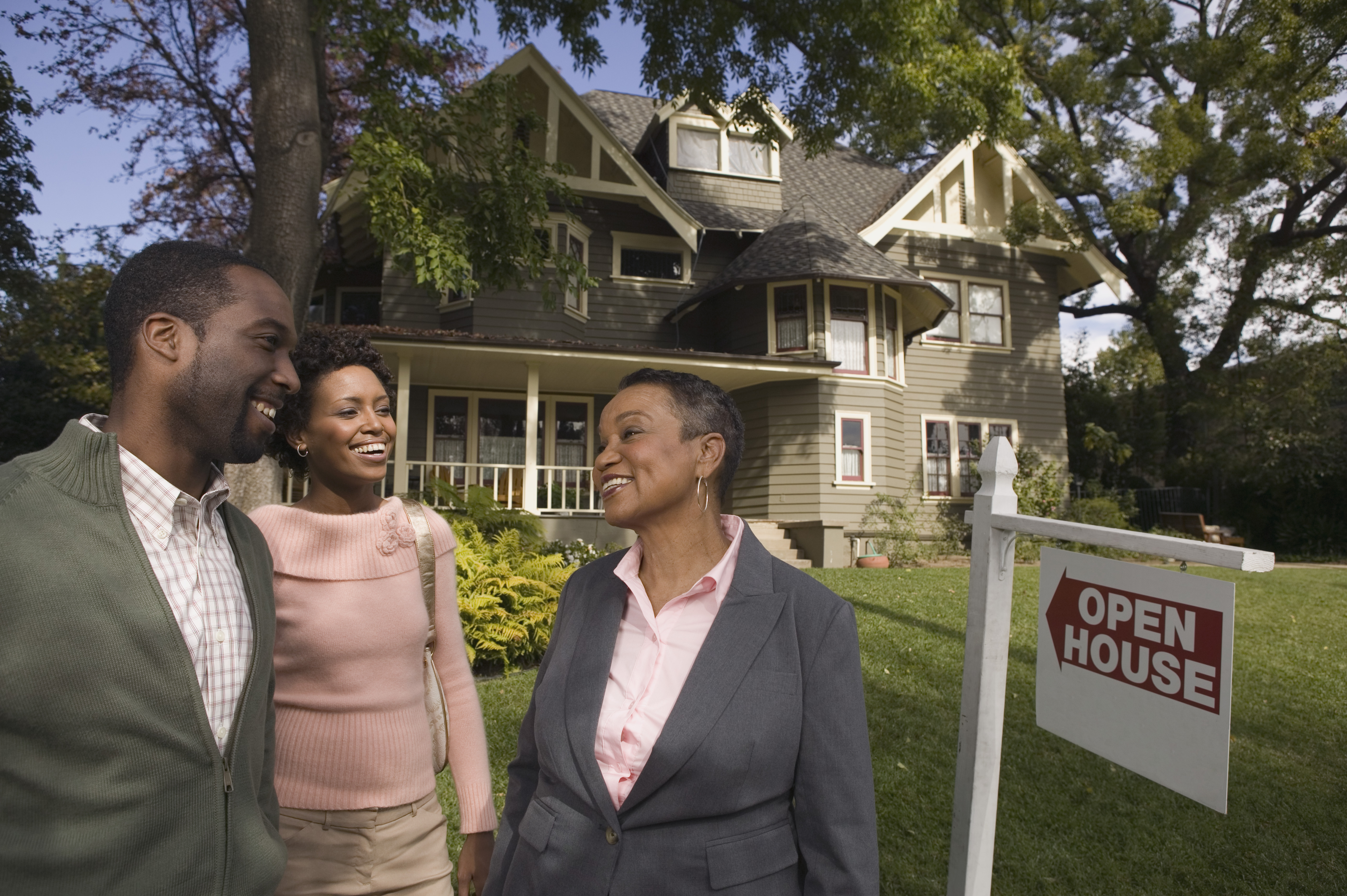 Happy couple with realtor at open house