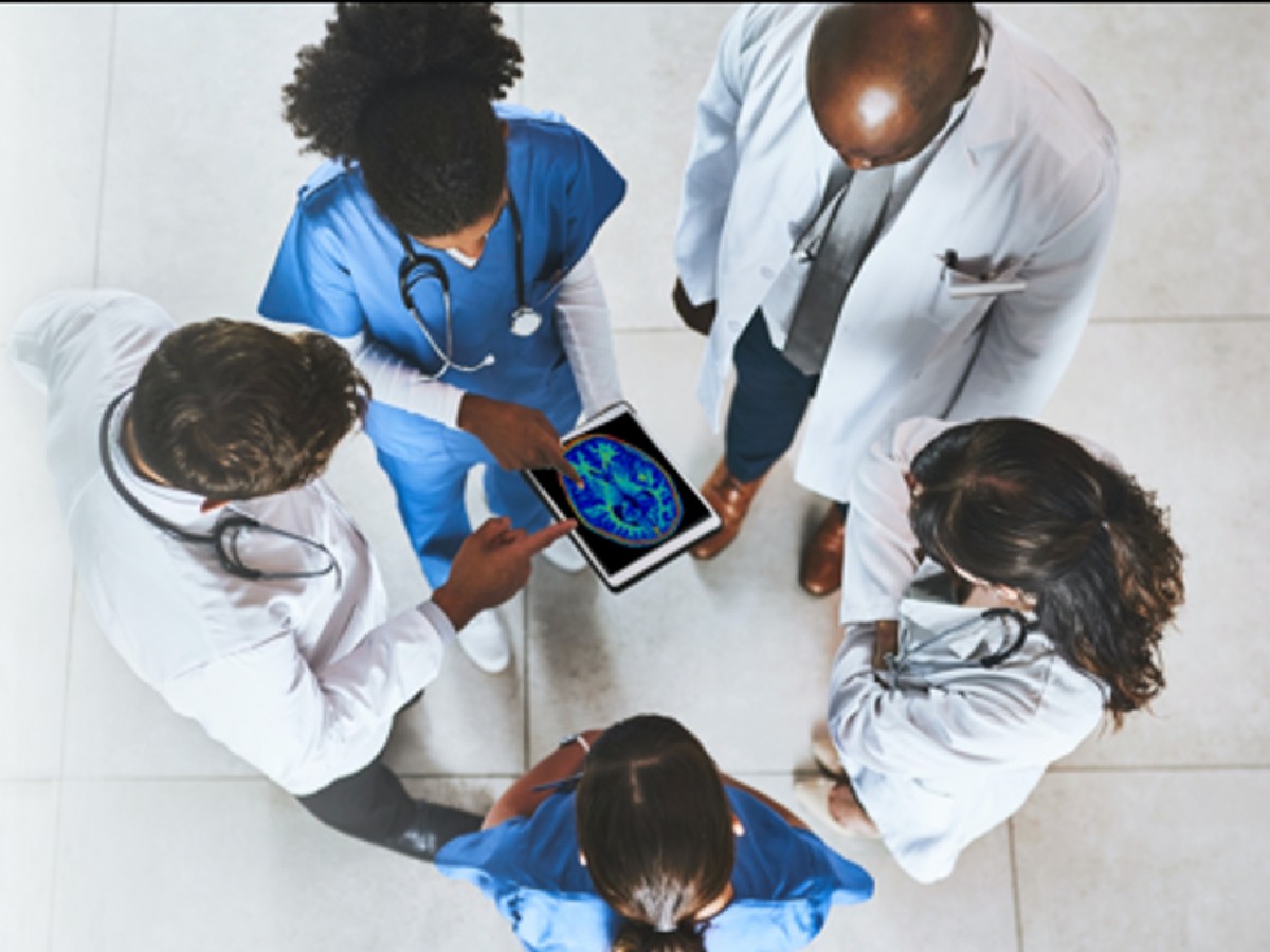 clinicians gather around tablet displaying brain image