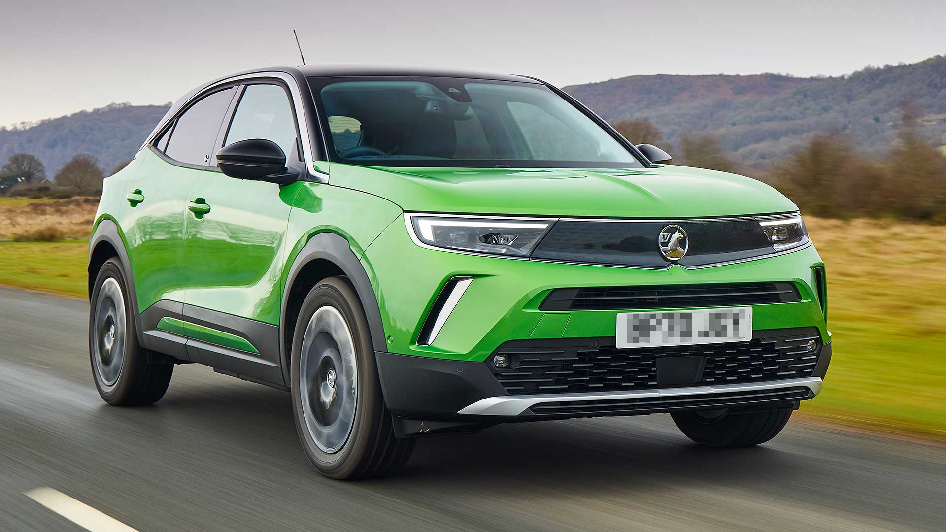 Bright green Vauxhall Mokka Electric driving on the road