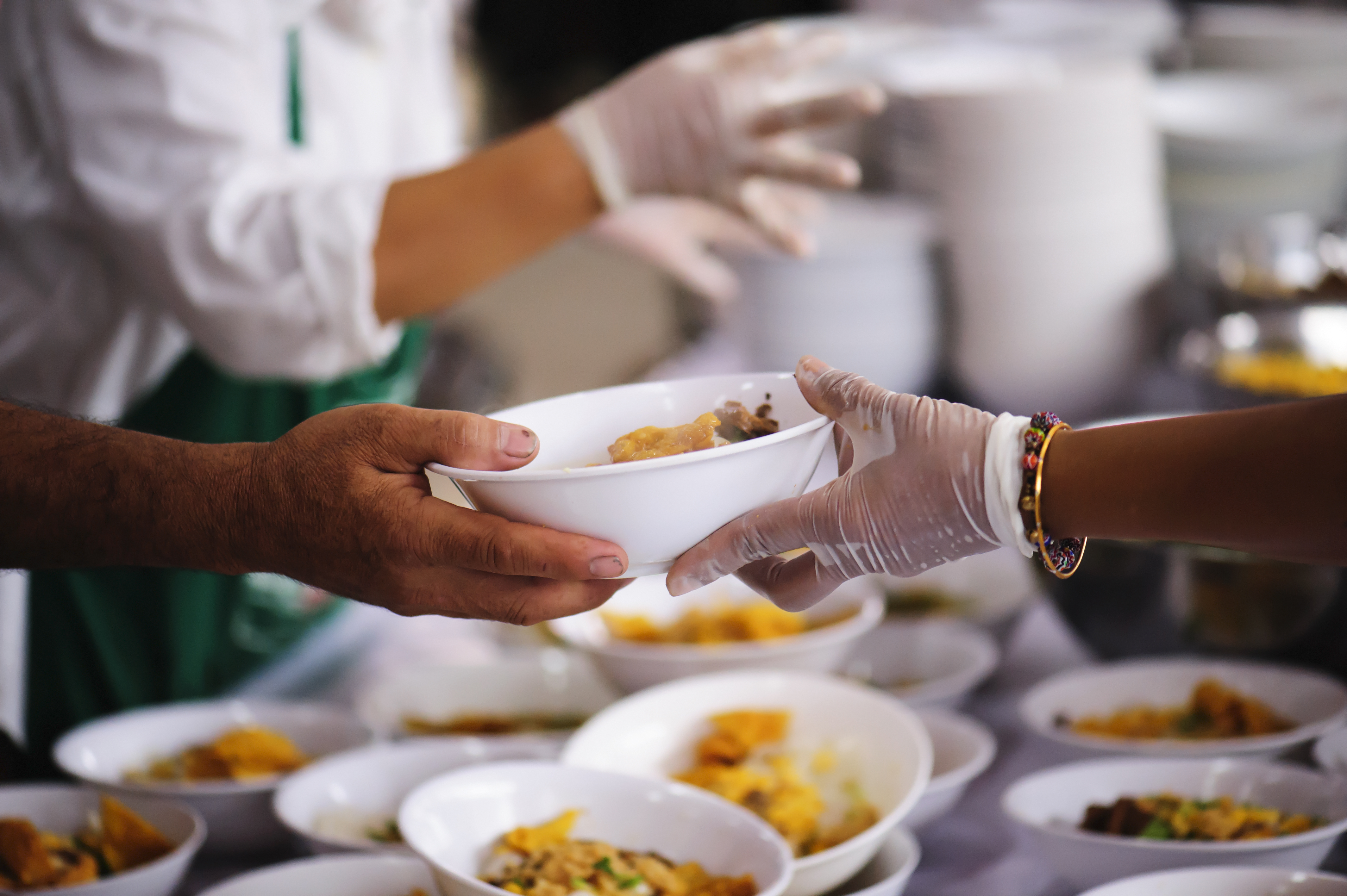 A person distributes food in a house of worship