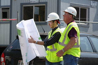 construction workers examine blueprint