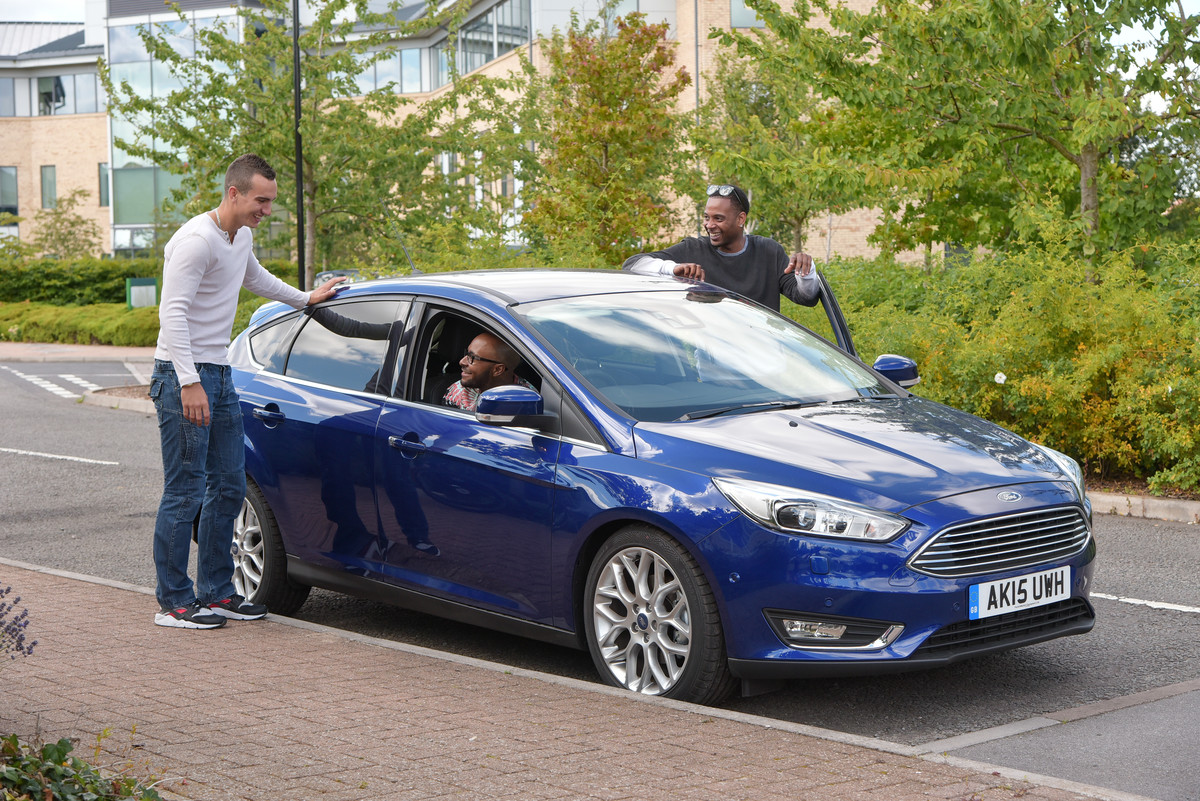 A Motability Scheme customer and his friends by a medium car