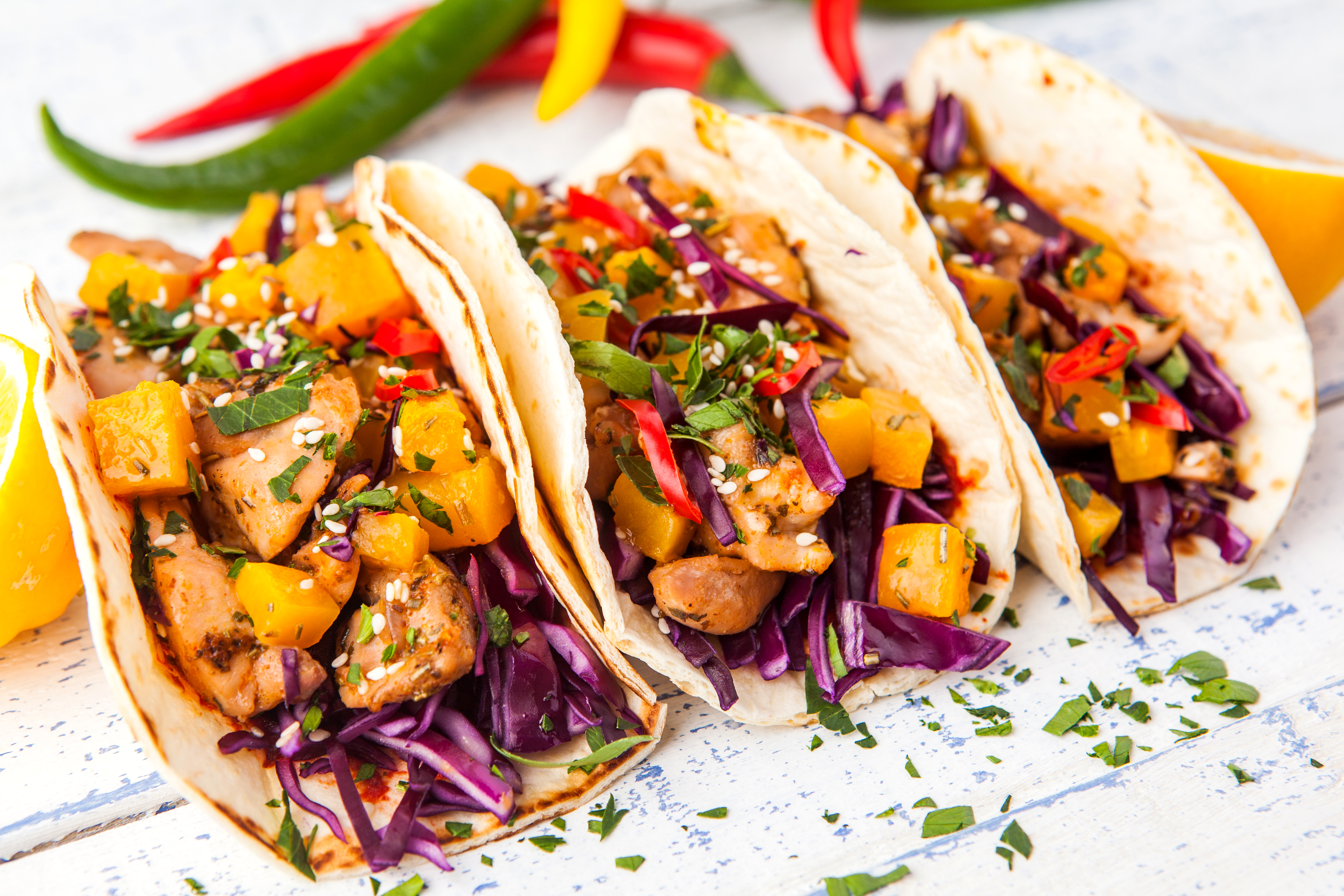 Mexican pork tacos with vegetables and pumpkin. Tacos on wooden white rustic background. Top view.
