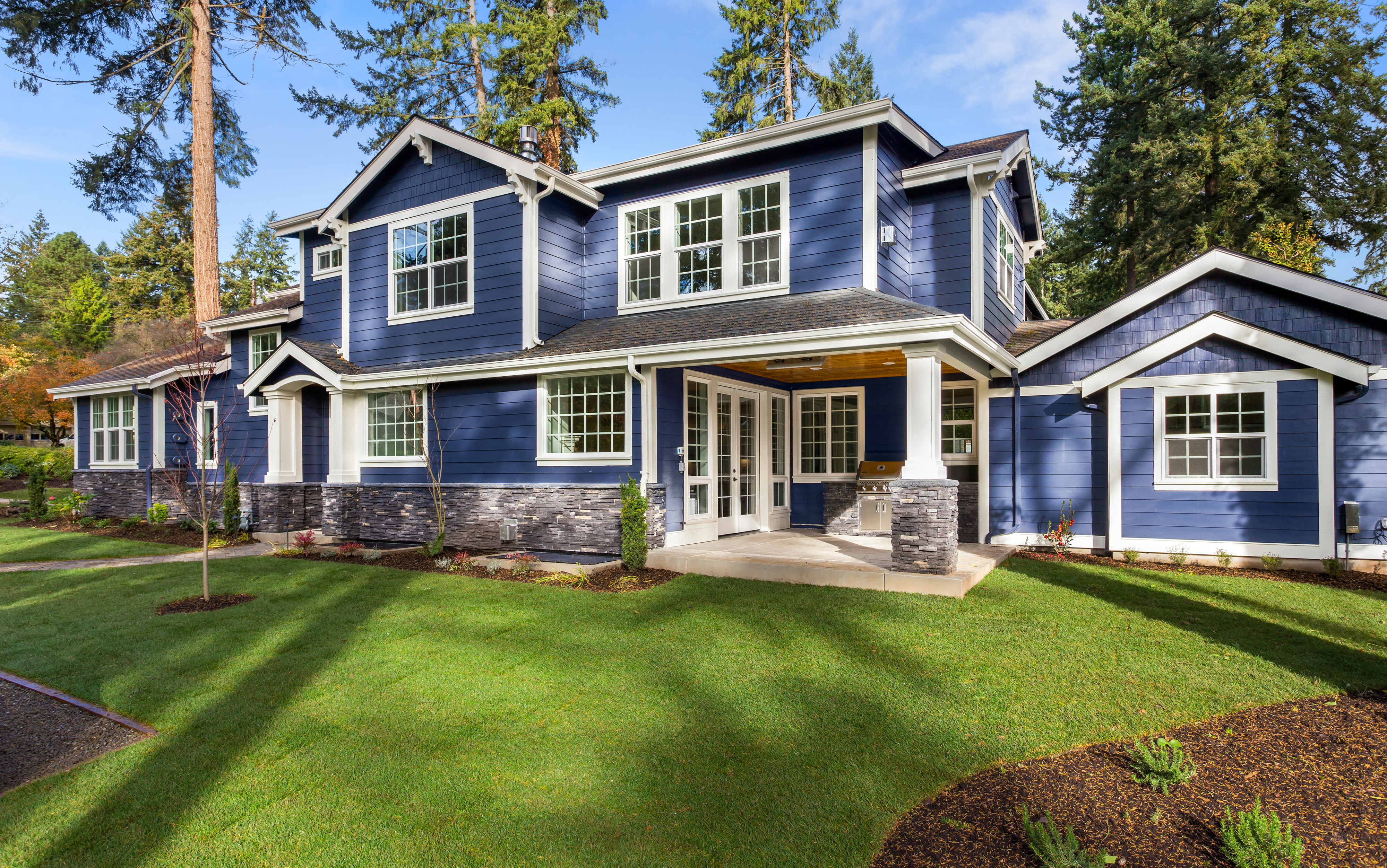 Beautiful luxury home exterior on bright sunny day with green grass and blue sky