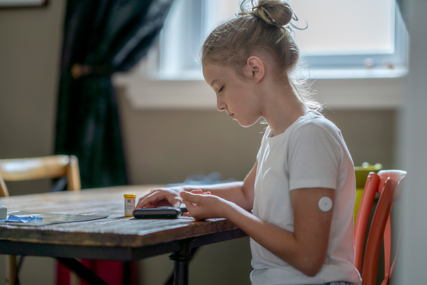 Deklica preverja raven glukoze v krvi ker ima sladkorno bolezen