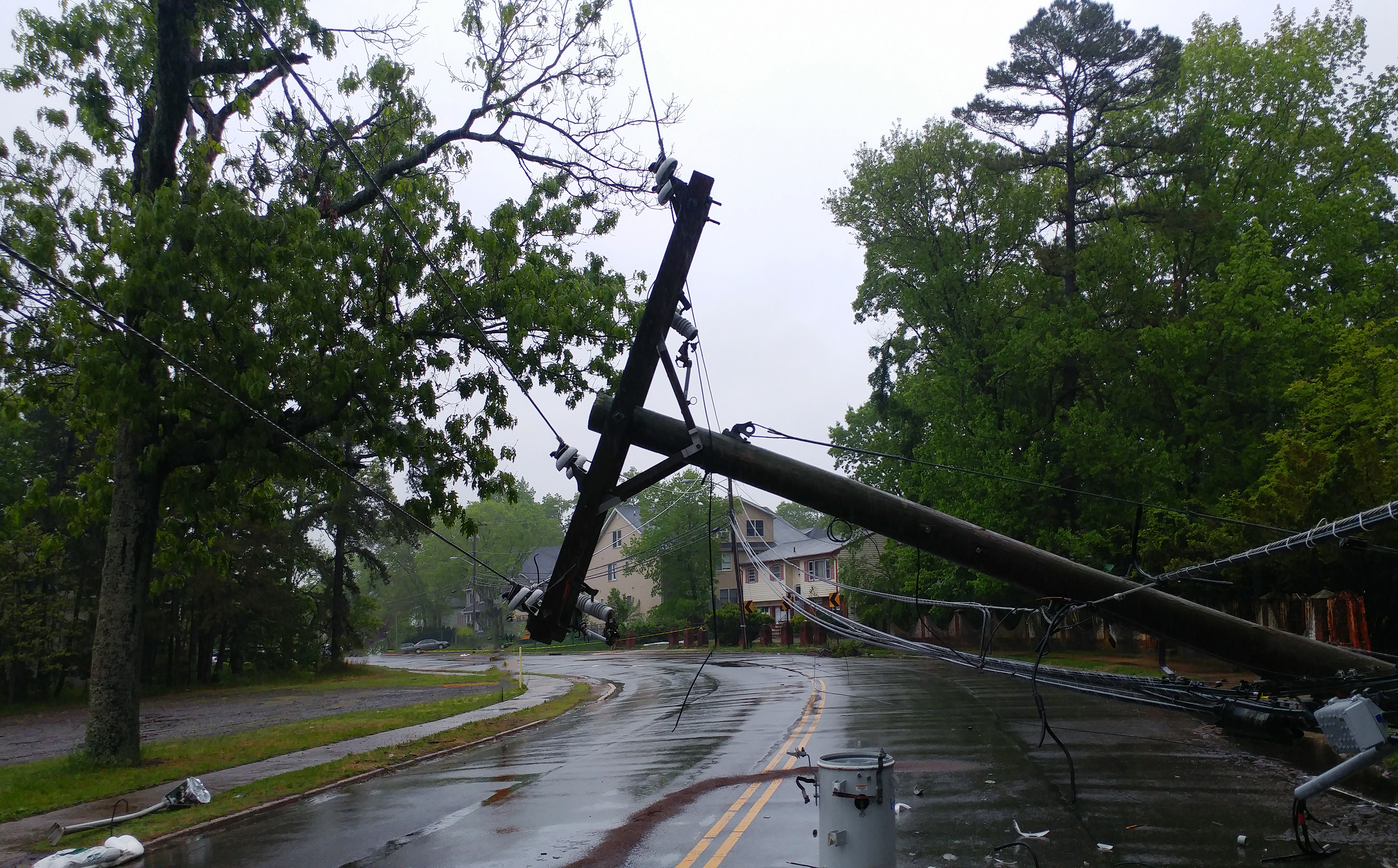 Storm damaged electric transformer on a pole and a tree