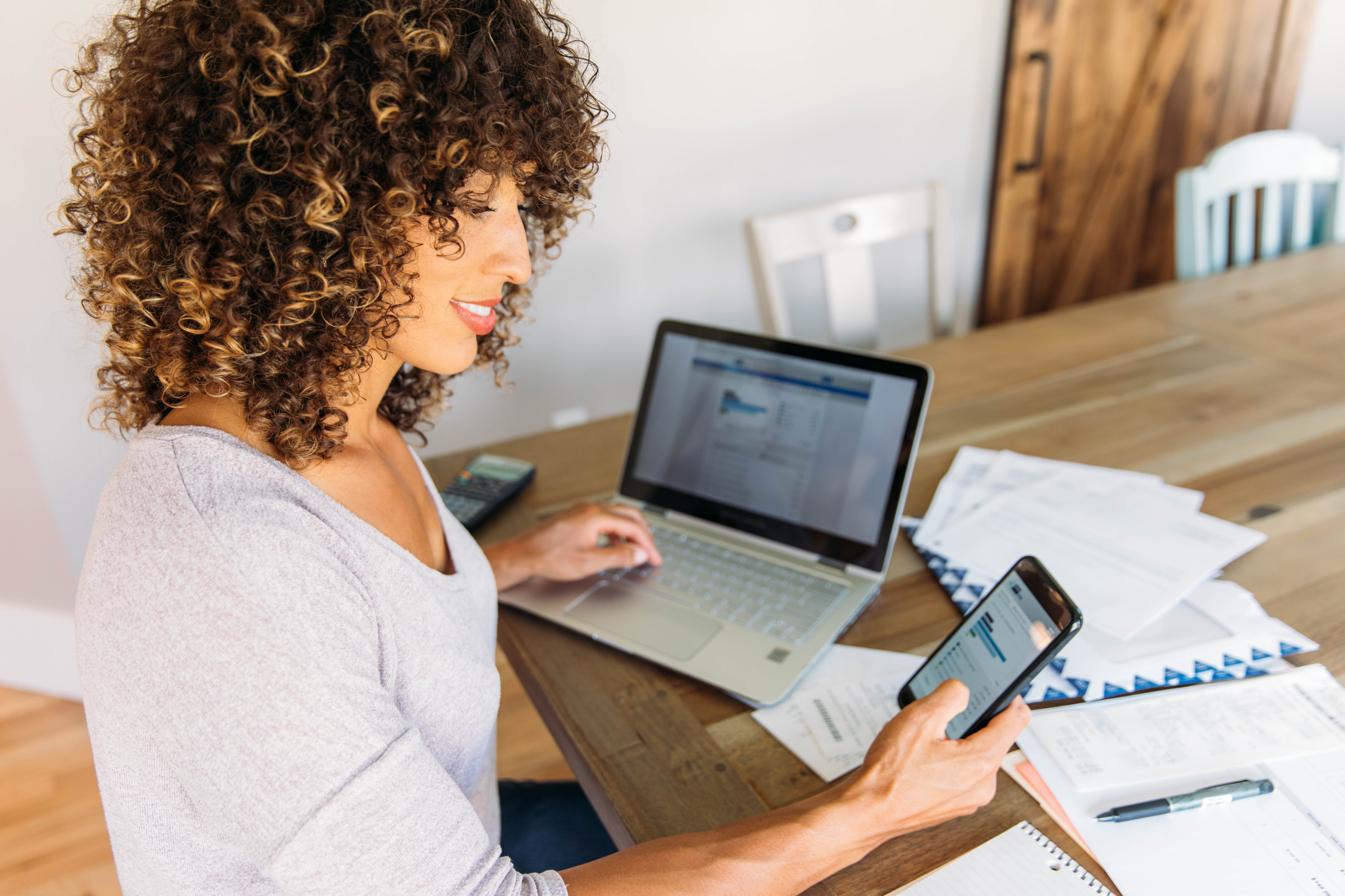 Woman Doing Finances at Home on Smart Phone