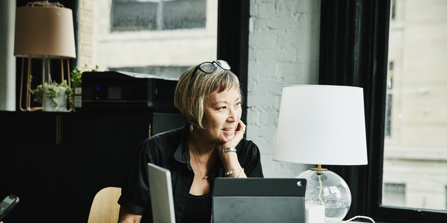 Portrait of smiling mature businesswoman seated at desk in creative office