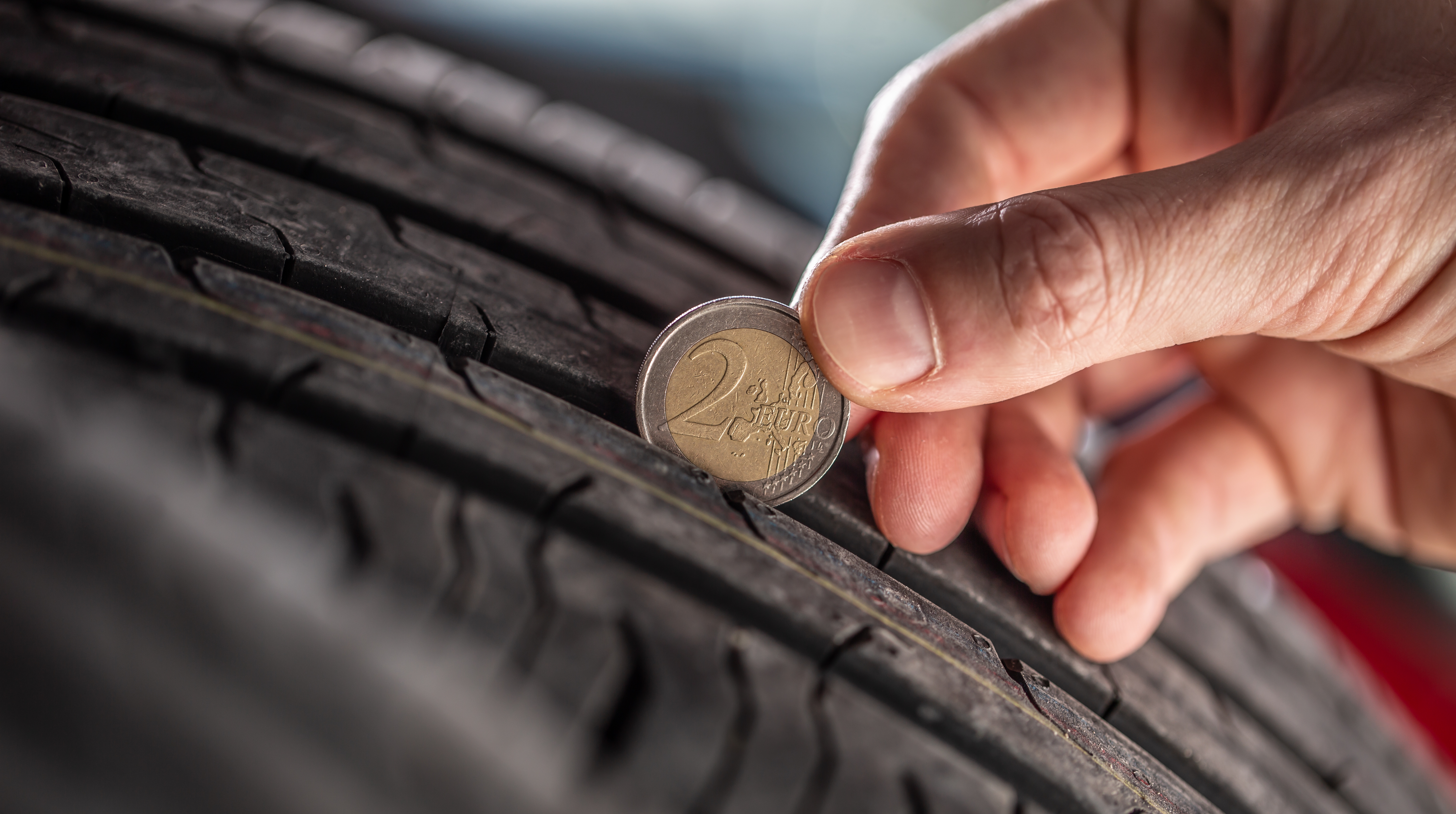 Trayectoria de neumáticos medida por una moneda de dos euros colocada en el patrón del neumático