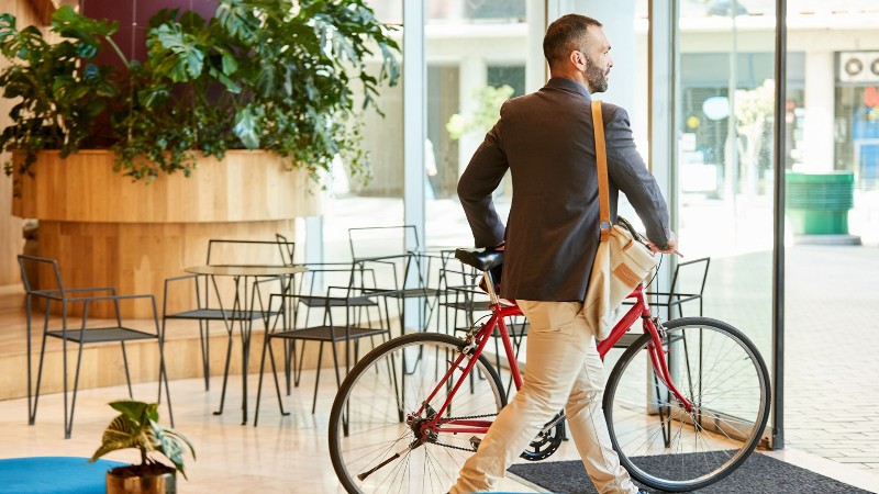 male-leaving-office-with-bike