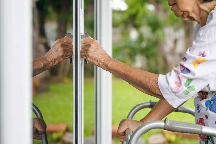 Varnejsi dom za starejše - Gospa s hojico odpira balkonska vrata